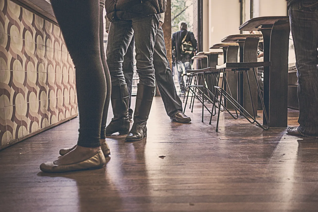Persone in fila al bancone di un bar, uno dei momenti che fanno pensare alla categoria